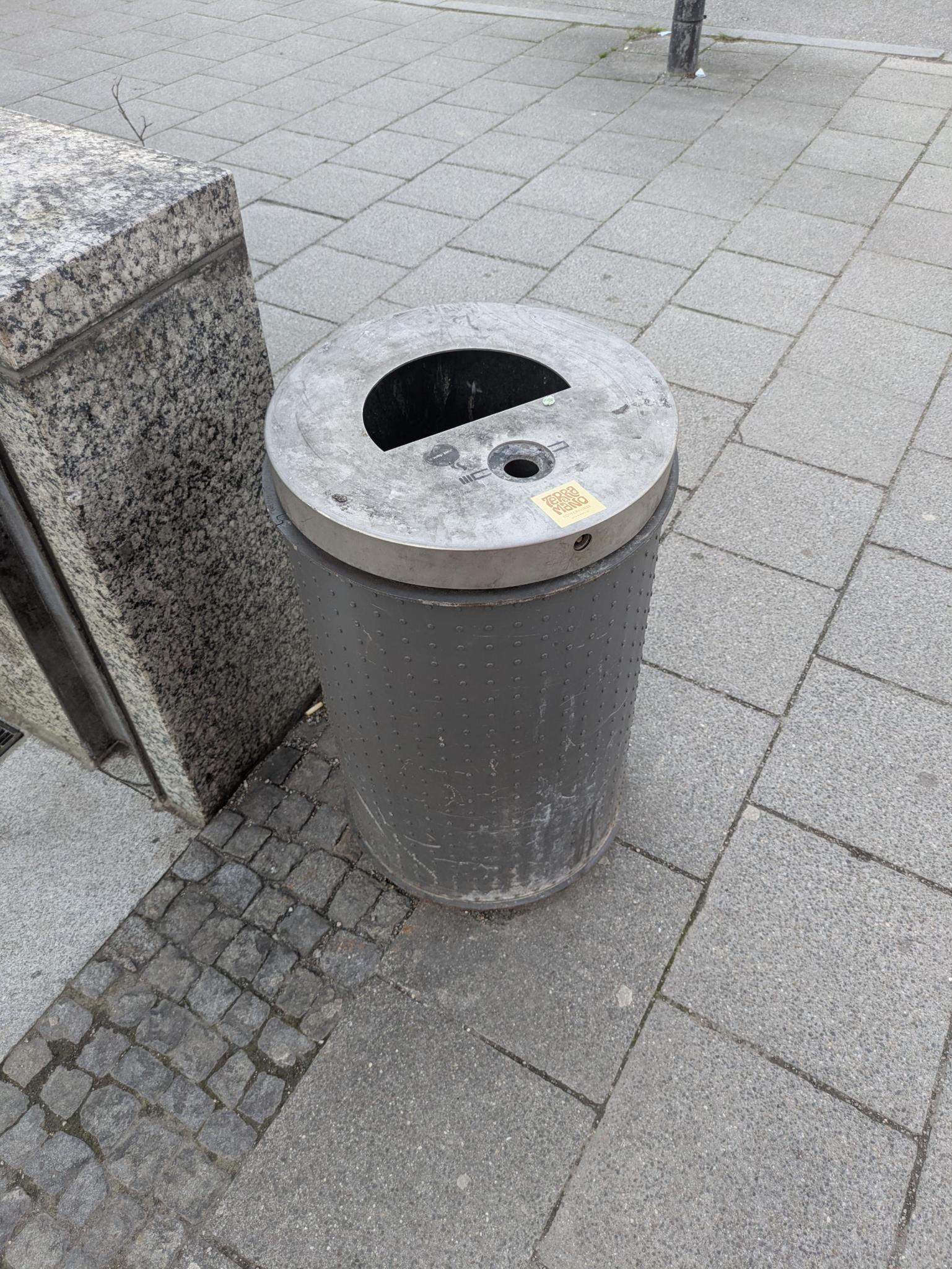 Ein Mülleimer neben einer einer Treppe